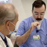 SAMUEL KAPLAN, right, clinical research assistant for Lifespan Corp., tests the Bubbler while Dr. Gregory Jay, a professor in the Department of Emergency Medicine and Division of Engineering at Brown University, looks on. COURTESY LIFESPAN CORP.