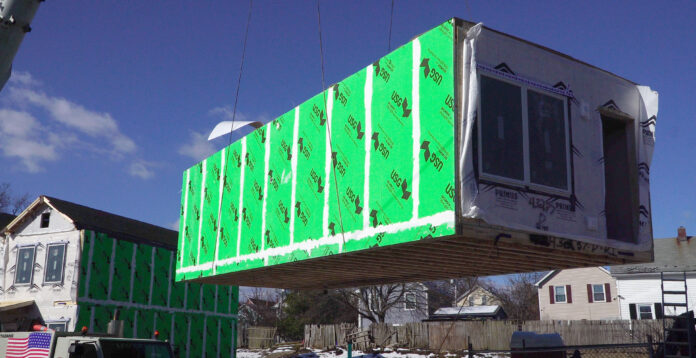 A MODULAR UNIT IS RAISED by a crane on Wednesday, March 2, 2022, to be lowered into place as part of the 
