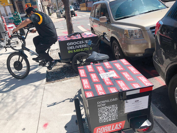 ON THE GO: A worker prepares to make a delivery on a bicycle in front of Gorillas mini-warehouse in the Brooklyn borough of New York City in April. Gorillas is one of several companies that venture capitalists have poured billions into in the latest pandemic delivery craze. / AP PHOTO/TALI ARBEL