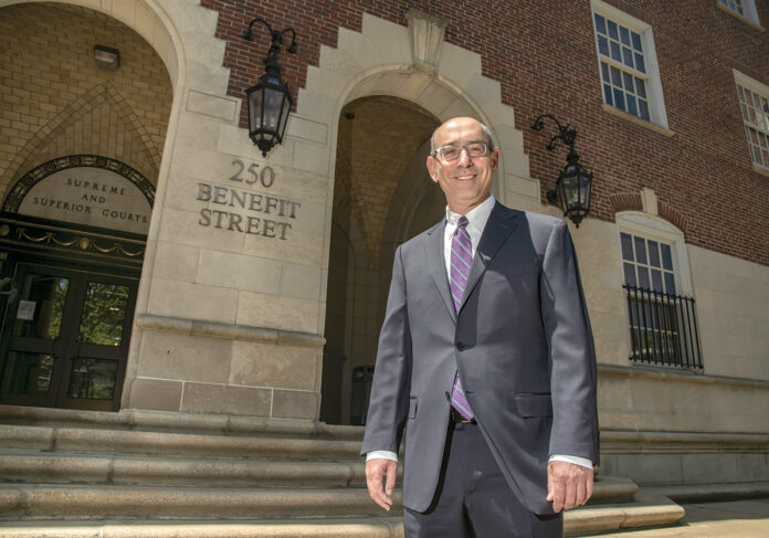 TEST CRITIC: Eric J. Mitnick, dean of the University of Massachusetts School of Law in Dartmouth, stands outside the Licht Judicial Complex in Providence. Mitnick is among the legal observers who believe the bar exam should be changed to better test the skills would-be attorneys will need to practice law. / PBN PHOTO/MICHAEL SALERNO