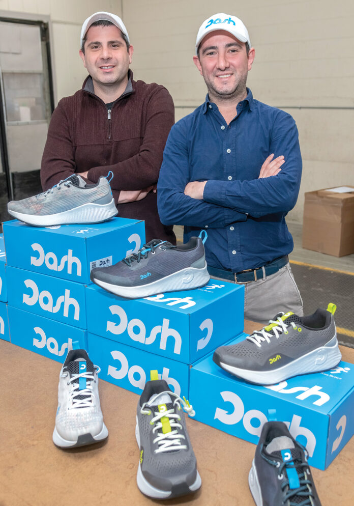 NEW SHOES: Joshua Swift, left, and David Maceroni, in their East Providence warehouse where they receive and ship out shoes for their new company, Dash Running LLC. / PBN PHOTO/MICHAEL SALERNO NEW SHOES: Joshua Swift, left, and David Maceroni, in their East Providence warehouse where they receive and ship out shoes for their new company, Dash Running LLC. / PBN PHOTO/MICHAEL SALERNO