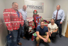 FEELING FESTIVE: The Province Mortgage Associates Inc. team poses near gift bags to be delivered as part of the company’s “Smiles to Seniors” holiday initiative. / COURTESY PROVINCE MORTGAGE ASSOCIATES INC.