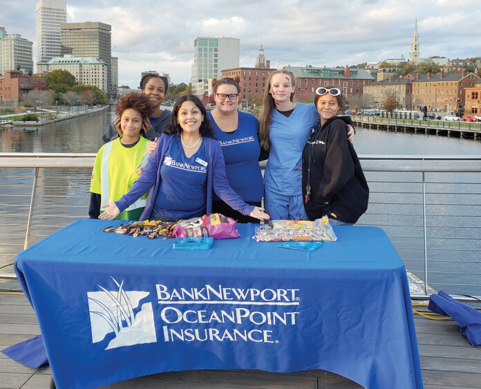 SWEET EVENING: BankNewport employees distribute candy as part of a Halloween event on the pedestrian bridge in Providence. / COURTESY BANKNEWPORT SWEET EVENING: BankNewport employees distribute candy as part of a Halloween event on the pedestrian bridge in Providence. / COURTESY BANKNEWPORT