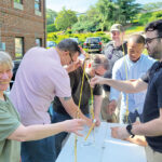PASTA POWER: Technology Advisory Group LLC employees work on a project in which they construct a tower made of spaghetti.  COURTESY TECHNOLOGY ADVISORY GROUP LLC