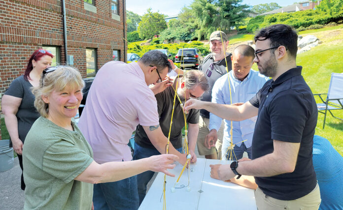 PASTA POWER: Technology Advisory Group LLC employees work on a project in which they construct a tower made of spaghetti.
COURTESY TECHNOLOGY ADVISORY GROUP LLC PASTA POWER: Technology Advisory Group LLC employees work on a project in which they construct a tower made of spaghetti.
COURTESY TECHNOLOGY ADVISORY GROUP LLC