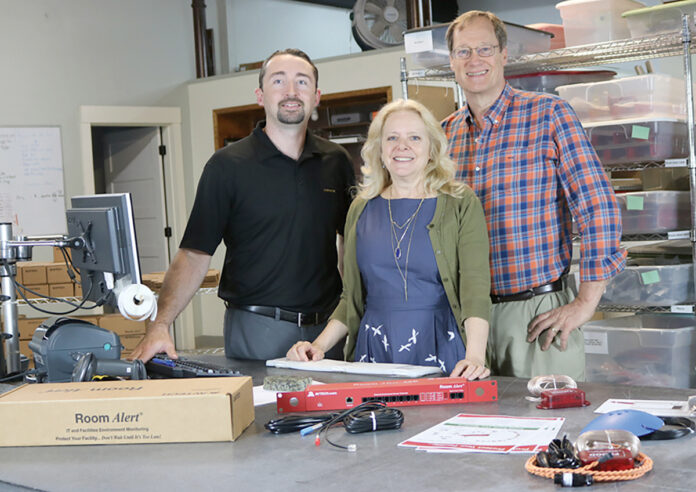 STAYING ALERT: AVTECH Software Inc. employees Rick Grundy, Anne Sigourney and Michael Sigourney pose with the company’s Room Alert environment monitor. / COURTESY AVTECH SOFTWARE INC. STAYING ALERT: AVTECH Software Inc. employees Rick Grundy, Anne Sigourney and Michael Sigourney pose with the company’s Room Alert environment monitor. / COURTESY AVTECH SOFTWARE INC.