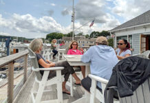 Coastline EAP/Rhode Island Student Assistance Services ON DECK: Employees for Coastline EAP/Rhode Island Student Assistance Services sit on a deck of a local restaurant catching fresh air. / COURTESY COASTLINE EAP