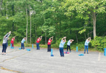 Ensuring employees’ health allows them to be present ‘on purpose’ at Groov-Pin
LIMBERING UP: Employees at Groov-Pin Corp. in Smithfield stretch before an outdoor yoga session, one of several initiatives the company introduced that became popular and is now a monthly event.
COURTESY GROOV-PIN CORP.