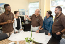 CHARGED UP: From left, E2SOL LLC electrical design engineer Mashhor Alshrieef, energy market research analyst Brianna Baro, Managing Principal Anthony Baro, head cheerleader Kelli Baro, and marketing analyst Brandon Baro in the company’s Providence office.  PBN PHOTO/TRACY JENKINS