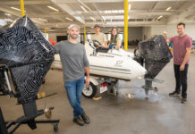 QUIET RIDE: Flux Marine Ltd. engineers Milo Ferrazzolo, Attila Delingat, Linden Zlotea and Greg Roche pose with boats and motors in their new Bristol location.   PBN PHOTO/DAVID HANSEN