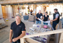UNDER CONSTRUCTION: J2 Construct Inc. President Jeff Lipshires, foreground, and his team go over plans for the company’s Pell Hotel renovation project in Middletown. PBN PHOTO/DAVID HANSEN