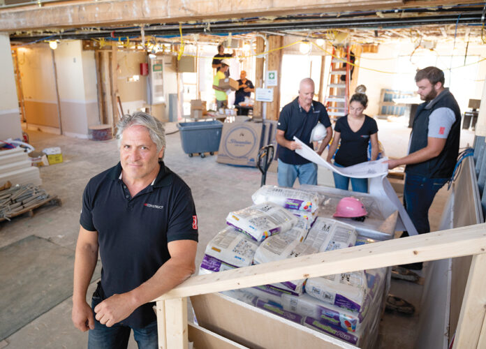 UNDER CONSTRUCTION: J2 Construct Inc. President Jeff Lipshires, foreground, and his team go over plans for the company’s Pell Hotel renovation project in Middletown. PBN PHOTO/DAVID HANSEN