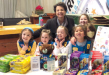 COOKIE SEASON: Janice DiPietro joins a group of Girl Scouts at a cookie booth. COURTESY GIRL SCOUTS OF  SOUTHEASTERN NEW ENGLAND