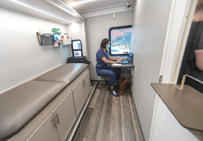 DOCTOR IS IN: Dr. Francesca Beaudoin works on her computer in an exam room inside CODAC Behavioral Healthcare’s new mobile treatment unit for opioid addiction. PBN PHOTO/MICHAEL SALERNO