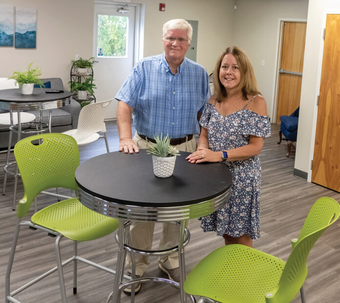 TRANSFORMED SPACE: David MacDonald, owner of CoWork Cumberland LLC, meets with office manager Marybeth Young in the cafe space. PBN PHOTO/MICHAEL SALERNO