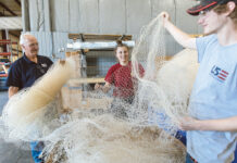 NOTHING BUT NET: From left, U.S. Extruders Inc. Plant Manager Wade Lippo and assemblers Lexus Falcone and Dan Brownhead work with fishing net.  PBN PHOTO/RUPERT WHITELEY