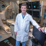MACHINE ­AIDED: Dr. Daniel Philbin, a cardiac electrophysiologist and director of the arrhythmia service at the Lifespan Cardiovascular Institute, in the operating room with Volta Medical Inc.’s VX1 monitor that assists in ablation ­surgeries.  PBN PHOTO/­MICHAEL SALERNO
