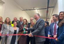 New Woonsocket Education Center officially opens GOV. DANIEL J. MCKEE, center, helps with local state education and business officials cut the ribbon on the new Woonsocket Education Center. / COURTESY R.I. OFFICE OF GOV. DANIEL J. MCKEE