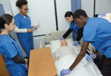 BEDSIDE MANNER: Students, from left, Camille Chiong, Cierra Odiembo, Gianna Sanchez and Djibril Gaye work in a lab at the Rhode Island Nurses Institute Middle College Charter High School in Providence.  PBN PHOTO/ELIZABETH GRAHAM