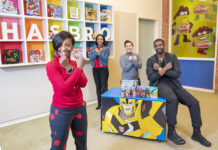 WAKANDA FOREVER: From left, Bryony Bouyer, Hasbro Inc.’s senior vice president of diversity and inclusion and multicultural strategy; Olga Lowe, manager of global brand development and marketing; Tayla Reo, product development manager; and Phil Johnston, senior creative writer, pose with arms crossed in a salute made famous in Marvel Entertainment LLC’s Universe’s “Black Panther” movie.  PBN PHOTO/DAVID HANSEN