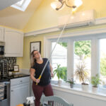 DUSTING: Mint Modern Clean LLC owner Cassandra Walz dusts a light fixture at a residence in Bristol. PBN PHOTO/MICHAEL SALERNO