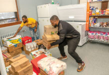 DELIVERING THE GOODS: Dustin Ford, left, community specialist in the Providence school system in charge of the Mount Pleasant High School food pantry, and John Nagbe, community outreach manager at We Share Hope, deliver donations to the high school’s recently opened food pantry, which provides students with food during holiday breaks, nights and weekends. PBN PHOTO/MICHAEL SALERNO