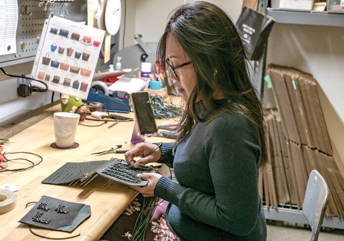 TIGHT WEAVE: Theresia Joseph works in the packaging and receiving department at Lotuff Leather, a handmade leather goods manufacturer in Providence that designs and sells bags, suitcases and other accessories. PBN PHOTO/MICHAEL SALERNO