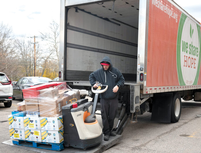 HEAVY LIFTING: Cliff Moniz, a driver/warehouse worker at the We Share Hope food pantry and market in East Providence, unloads food ­donations.  PBN FILE PHOTO/­MICHAEL SALERNO