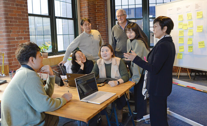 EARLY ­SUPPORT: New England Medical Innovation Center co-founder Lydia Shin Schroter, right, leads an international team at the organization’s Providence headquarters.  PBN PHOTO/­ELIZABETH ­GRAHAM