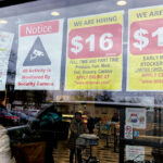 IN THE OPEN: Hiring signs displayed at a grocery store in Arlington Heights, Ill., tout the pay rate. Employers are increasingly posting salary ranges for job openings, even in states where it’s not mandated by law.  AP FILE PHOTO/NAM Y. HUH
