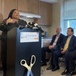 MICHELLE LEE, left, speaks during Thursday's press event cutting the ribbon-cutting event on new homeless family apartments in Warwick for Crossroads Rhode Island. Lee will become a new resident in the apartments. Also pictured are R.I. Housing Secretary Stefan Pryor, middle, and House Speaker K. Joseph Shekarchi, D-Warwick. / COURTESY CROSSROADS RHODE ISLAND