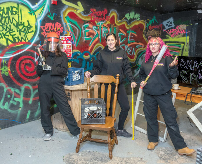 FAMILY FUN: Samantha Rodriguez, center, is the co-owner of Smash ‘N’ Splash, a new rage room in West Warwick. Her daughter Nayliana Rodriguez, left, and niece Alyssa DePina work as assistants at the business. PBN PHOTO/MICHAEL SALERNO