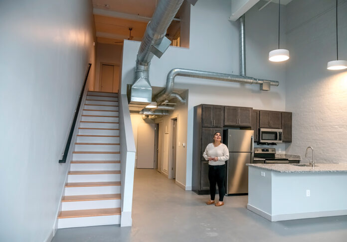OPEN SPACE:  Meliza ­Urquhart, community manager at Paragon Mill in Providence, shows one of the new units offered at “workforce” rates for people who earn between 80% and 120% of the area’s median income. Demand in that slice of the housing market is far beyond the supply.  PBN PHOTO/ MICHAEL SALERNO