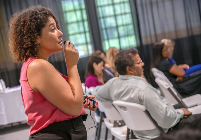 HELPING OUT: Shirley Moore, left, owner of Be Moore Interpreting LLC in Pawtucket, provides interpreting services for the attendees at the Latino Financial Summit at Farm Fresh in Providence.  PBN FILE PHOTO/MICHAEL SALERNO