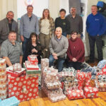 SEASON OF GIVING: Envision Technology Advisors LLC employees wrap gifts during its annual Adopt A Family Wrapping Party.  COURTESY ENVISION TECHNOLOGY ADVISORS LLC
