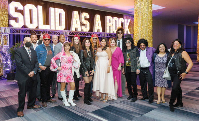 ROCKING OUT: Amgen Rhode Island employees dress up for its Solid As A Rock 1980s-themed gala.  COURTESY AMGEN RHODE ISLAND