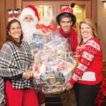 HOLIDAY GIVING: Amica Mutual Insurance Co. employees, with an assist from Santa, continue a tradition of holiday giving with a Penny Social, which raised more than $7,000 to benefit Meals on Wheels of Rhode Island.  COURTESY AMICA MUTUAL INSURANCE CO.