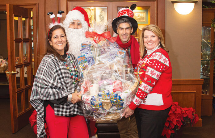 HOLIDAY GIVING: Amica Mutual Insurance Co. employees, with an assist from Santa, continue a tradition of holiday giving with a Penny Social, which raised more than $7,000 to benefit Meals on Wheels of Rhode Island.  COURTESY AMICA MUTUAL INSURANCE CO.