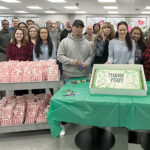 SWEET CELEBRATION: Staffers at Swarovski Optik North America Ltd. gather for snacks and cake for its Employee Appreciation Day.  COURTESY SWAROVSKI OPTIK NORTH AMERICA LTD.