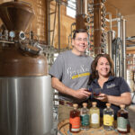 FRESH SPIRITS: Grey Sail Brewing Co. LLC co-owners Alan and Jennifer Brinton show off some of the spirits from their newly launched South County Distillers venture , which is housed inside their Grey Sail Brewing facility in Westerly. PBN PHOTO/DAVID HANSEN