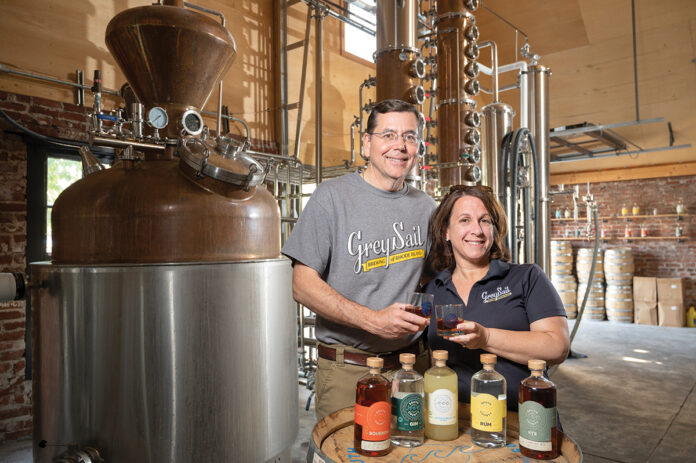 FRESH SPIRITS: Grey Sail Brewing Co. LLC co-owners Alan and Jennifer Brinton show off some of the spirits from their newly launched South County Distillers venture , which is housed inside their Grey Sail Brewing facility in Westerly. PBN PHOTO/DAVID HANSEN