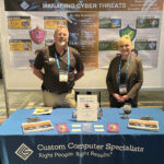 Custom Computer Specialists Inc. ON DISPLAY: Custom Computer Specialists Inc. employees Mason Sock and Suzanne McLaughlin stand at a station promoting the company at an event.
COURTESY CUSTOM COMPUTER SPECIALISTS INC.