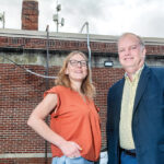CONNECTORS: Jennifer Hawkins, left, CEO and president of the nonprofit ONE Neighborhood Builders, and David Marble, CEO and president of OSHEAN Inc., check new network antennae on the roof of ONE Neighborhood Builders’ Providence headquarters. The antennae are helping to provide free Wi-Fi to residents in the Olneyville neighborhood.  PBN PHOTO/­MICHAEL SALERNO
