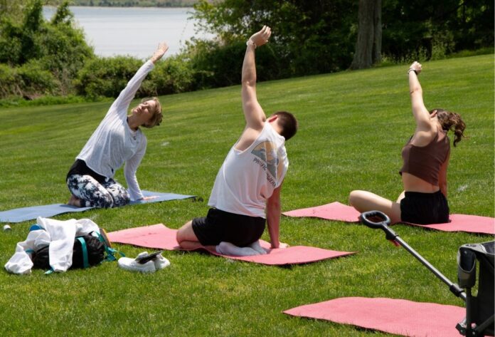 ROGER WILLIAMS UNIVERSITY students have a yoga session on campus during the spring. Colleges are now starting to focus on mental health and socialization recovery from the COVID-19 pandemic. / COURTESY ROGER WILLIAMS UNIVERSITY