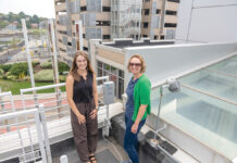 UP IN THE AIR: Grace Berg, left, Breathe Providence project coordinator, and Meredith Hastings, Brown University professor, check on one of the group’s air sensors in the Jewelry District in Providence.  PBN PHOTO/­MICHAEL SALERNO