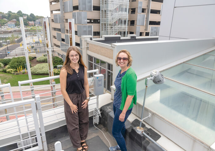 UP IN THE AIR: Grace Berg, left, Breathe Providence project coordinator, and Meredith Hastings, Brown University professor, check on one of the group’s air sensors in the Jewelry District in Providence.  PBN PHOTO/­MICHAEL SALERNO