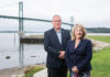 ENGINEERING MARVEL: The R.I. Turnpike and Bridge Authority is implementing a dehumidification system to help preserve the cables and anchorages on the Mount Hope Bridge. Pictured with the bridge in the background are RITBA Director of Engineering Eric Seabury and Executive Director Lori Caron Silveira. PBN PHOTO/DAVID HANSEN