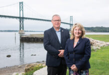 ENGINEERING MARVEL: The R.I. Turnpike and Bridge Authority is implementing a dehumidification system to help preserve the cables and anchorages on the Mount Hope Bridge. Pictured with the bridge in the background are RITBA Director of Engineering Eric Seabury and Executive Director Lori Caron Silveira. PBN PHOTO/DAVID HANSEN