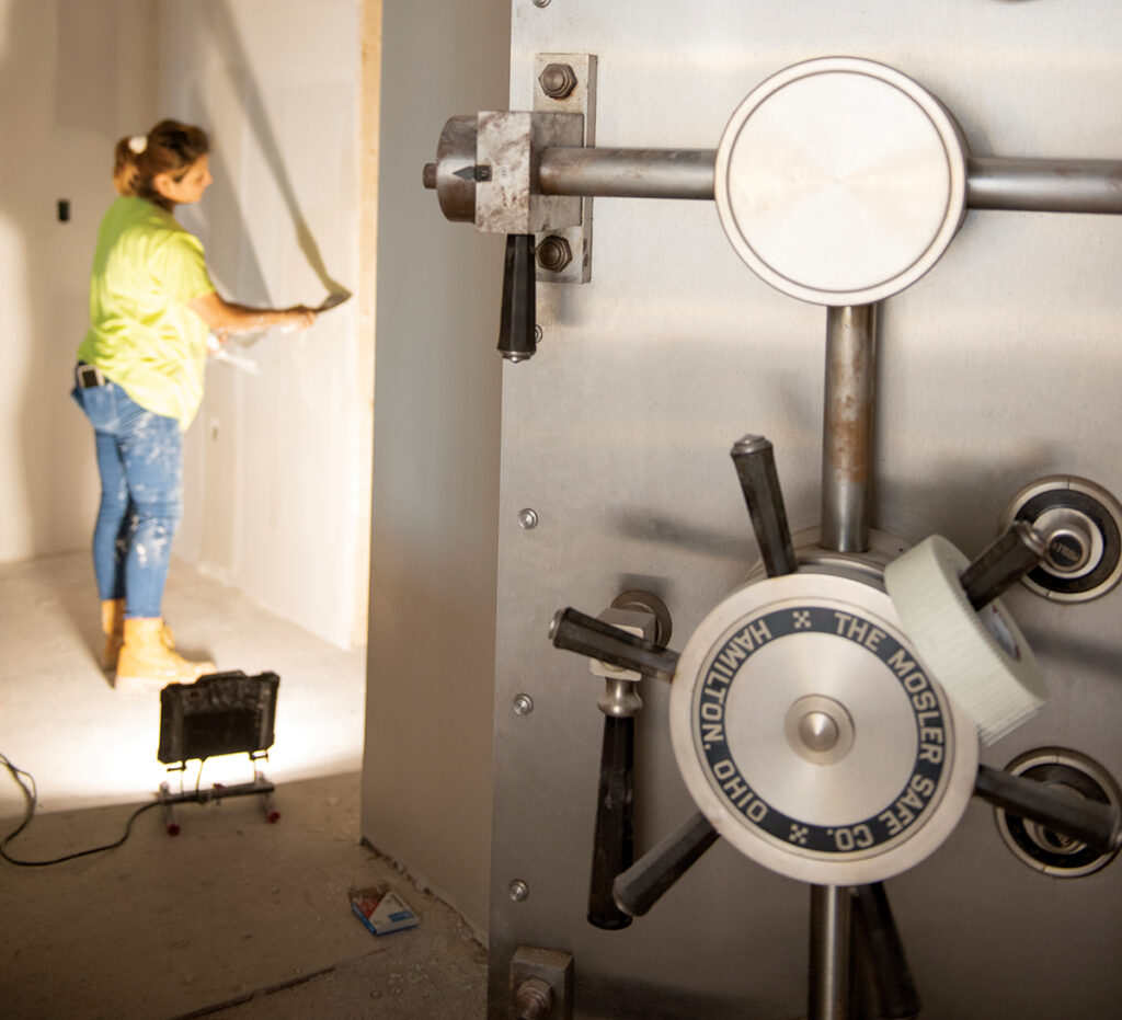 MOVING IN: Construction worker Fabiola Roman installs drywall on what will become Bank Rhode Island’s newest branch, this one in Newport. BankRI is renovating a space that was once a Bank of America location on Bellevue Avenue. It will open in December. The only thing that remains from the old bank is the vault.
PBN PHOTO/DAVID HANSEN