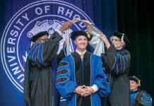 A matter of degrees: Some R.I. colleges offer DBA REWARDING MOMENT: Associate professor Georges Tsafack, left, executive director of the University of Rhode Island’s Doctorate of Business Administration program, and associate professor Jessica Strübel, right, place a doctoral hood on Michael Toomey during a graduation ceremony in August. Toomey was one of six people who received a DBA in the inaugural class of the program.
COURTESY UNIVERSITY OF RHODE ISLAND